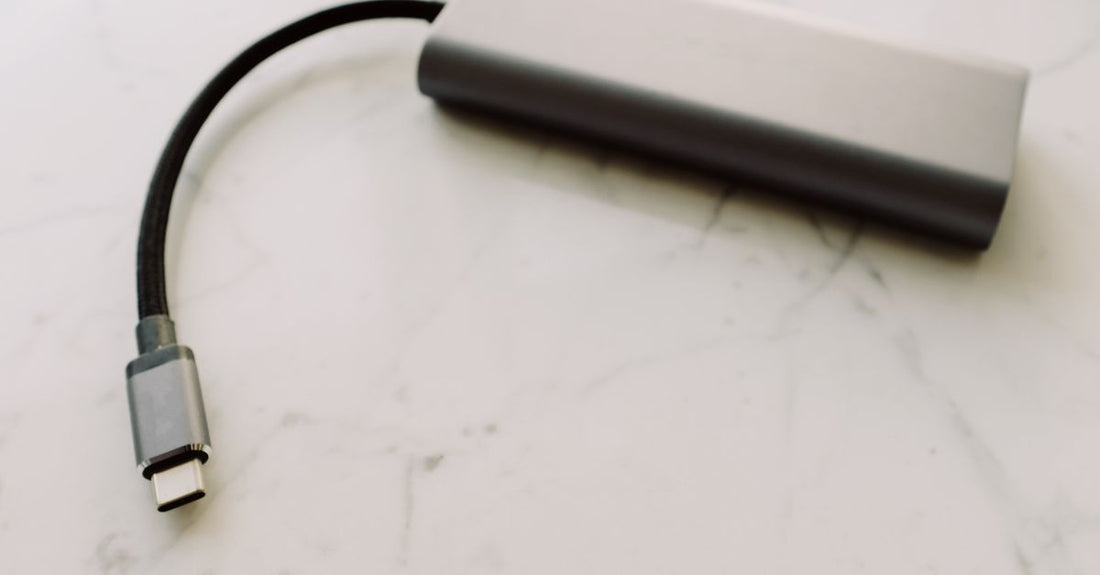 Close-up of a USB-C adapter on a marble surface, showcasing modern technology.